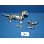 A family of white metal Dachshund ornaments plus one larger Dachshund.