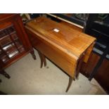 An Edwardian Mahogany lightwood strung Sutherland Table with curved legs and a small trinket drawer