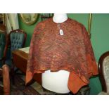 A child's hand woven orange Poncho.