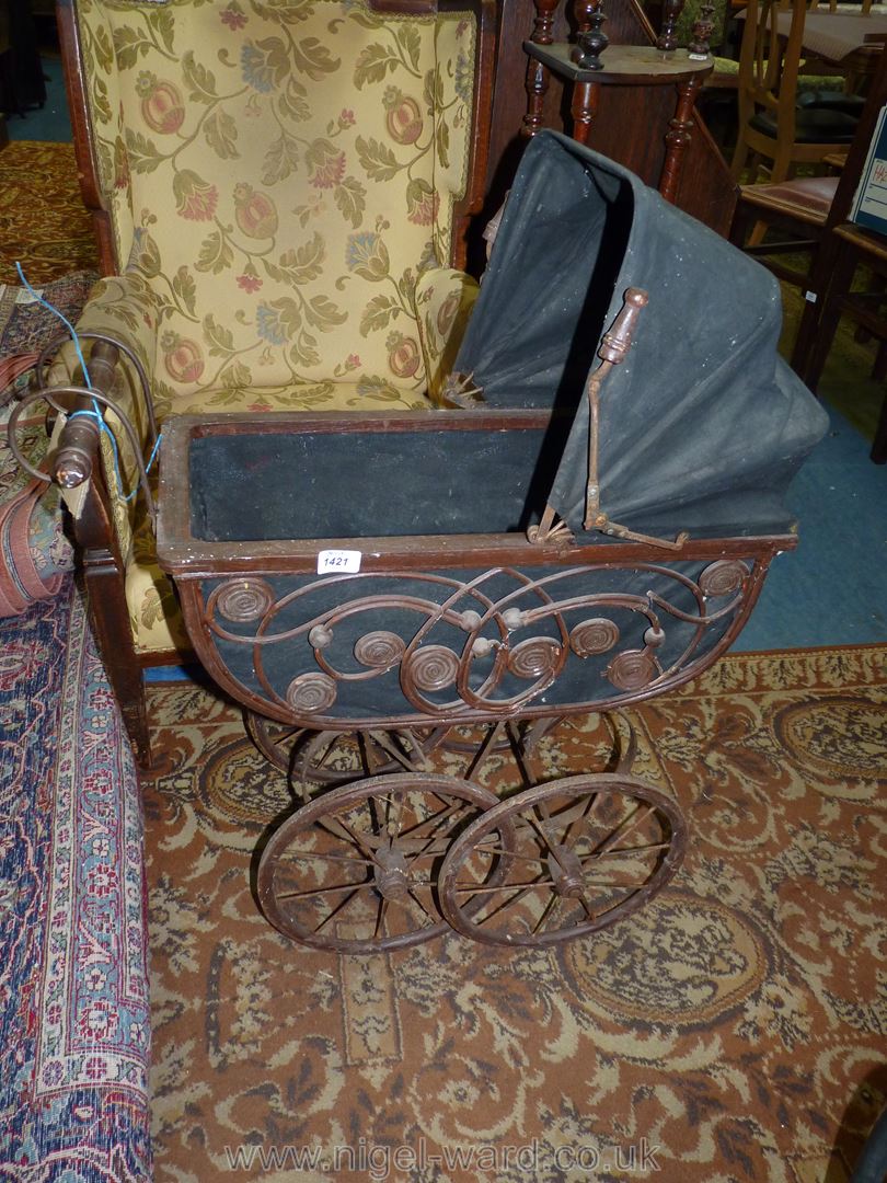 A vintage Doll's Pram with wooden frame and canvas hood,