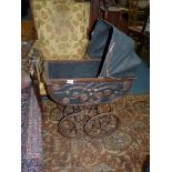 A vintage Doll's Pram with wooden frame and canvas hood,