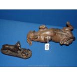 A heavy cast composite sculpture in a bronze patina of a rolling Dachshund,