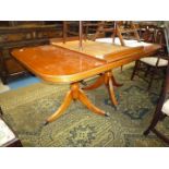 A contemporary Mahogany finished cross-banded with Yew wood double pedestal Dining Table on three