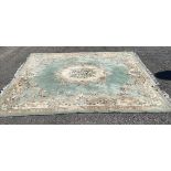 A large floral Rug with fringing in cream and green. 139" x 107".