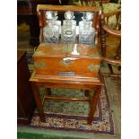 A good Oak three decanter Tantalus on a stand, mirror backed with brass fittings and carry handles.