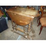 An Oak dropleaf, swing leg Occasional Table on turned supports,