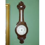 An elegant carved Oak cased Aneroid Barometer with thermometer,