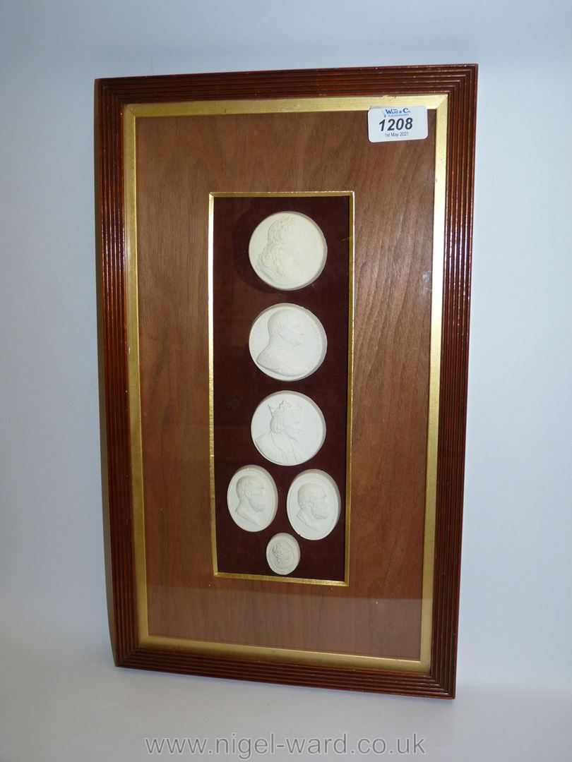 A framed small group of classical plaster cast medallions.