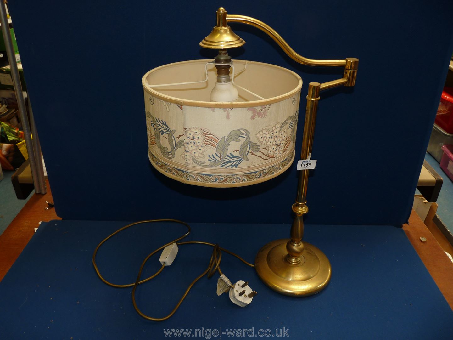 A brass cantilever lamp with cream shade.