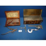 A Grand-Fein Lufkin German saw teeth setter and a tin containing Moore & Wright micrometer,