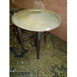 A circular Brass topped occasional Table, the top profusley engraved and with Eastern script,