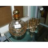 A gold trimmed liqueur set with six glasses and a bulbous decanter and stopper, 24 ct. foreign.