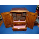 An oak Smokers cabinet with two drawers and five compartments with carved panels to the doors,