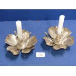 A pair of white metal candlestick holders in the form of flowers,