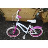 A child's pink and white bike.