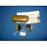 A pair of WWII British aviator sunglasses with leather sides in original metal case,