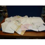 A box of antique embroidered linen and lace tablecloths, handkerchiefs, etc.