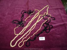 Two jet necklaces and three simulated pearl necklaces.