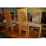 A set of four slat back dining chairs.
