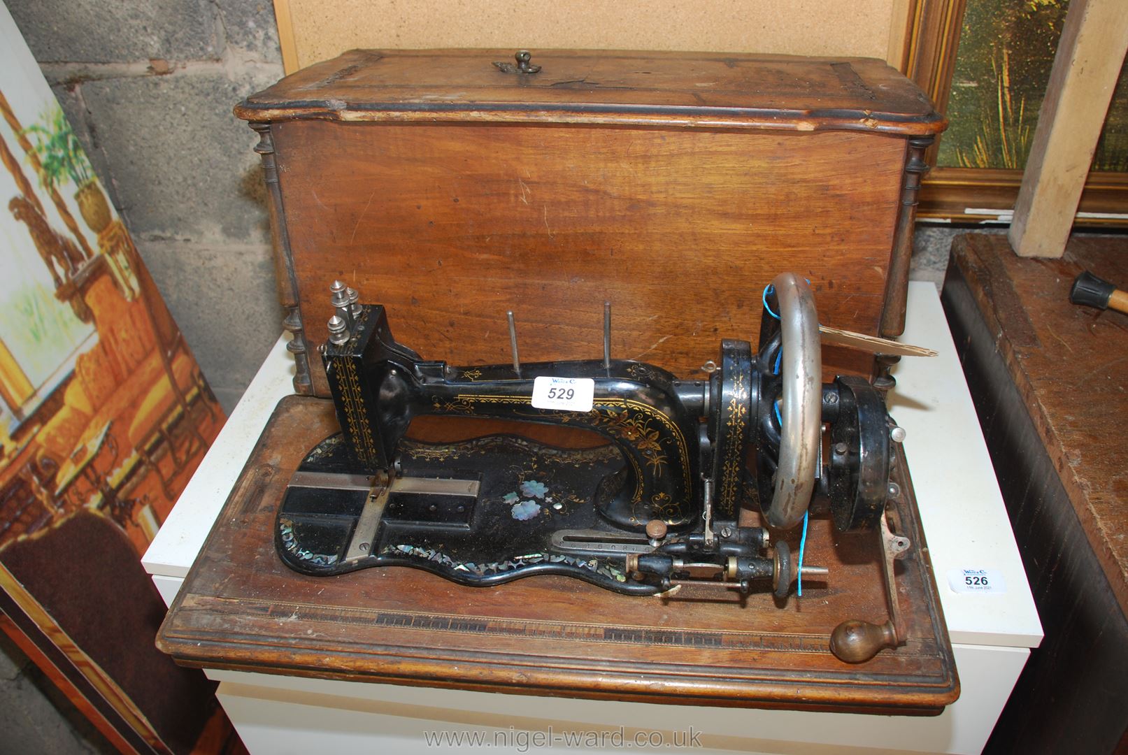 A hand sewing machine in wooden case.