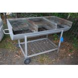 A large three stage Barbecue on wheeled frame, 5' wide x 30''.