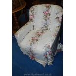 An upholstered nursing chair with a fitted floral cover.