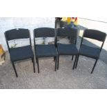 Four black cushioned office chairs.