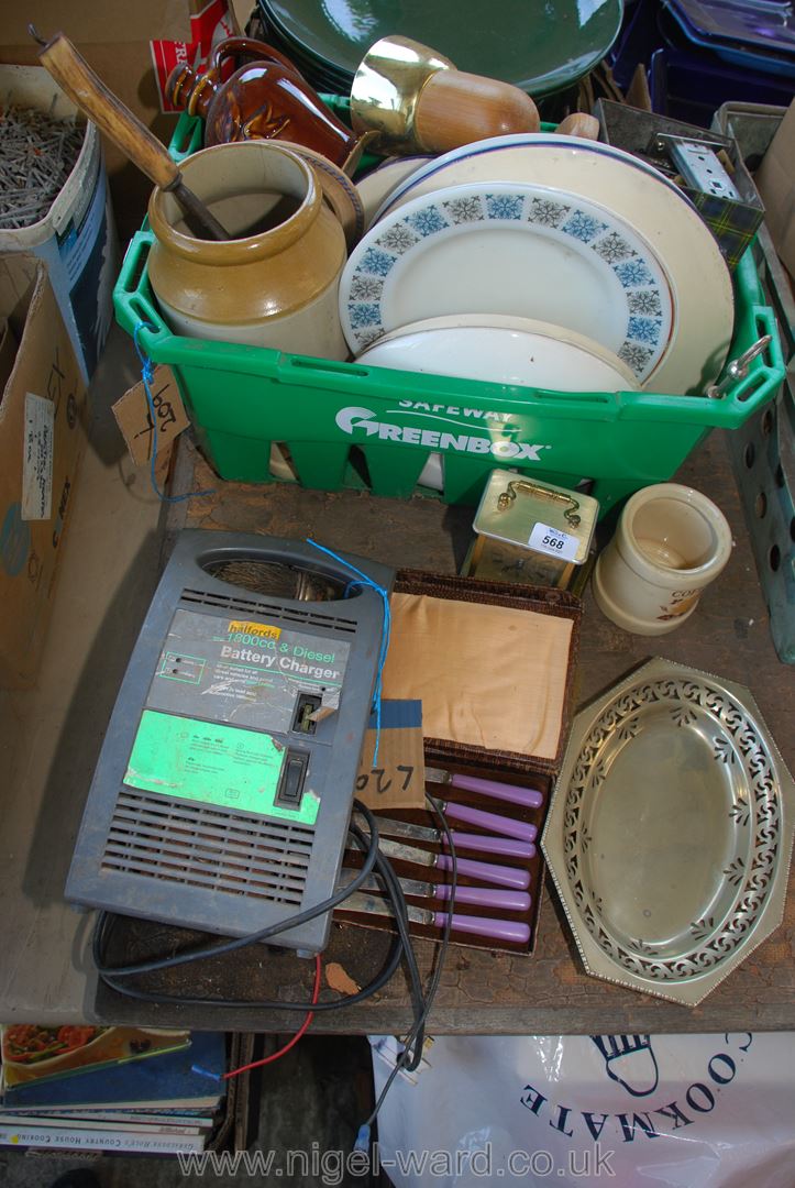 A basket of various plates, lights, china, butter knives and a car battery charger.