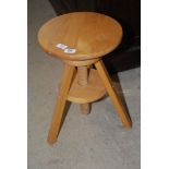 A circular adjustable pine stool.