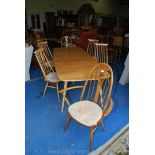 An Ercol extending table and four chairs and two carvers in slightly darker wood with swan motifs