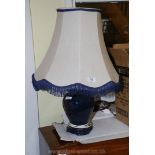 A blue pottery table lamp and shade.