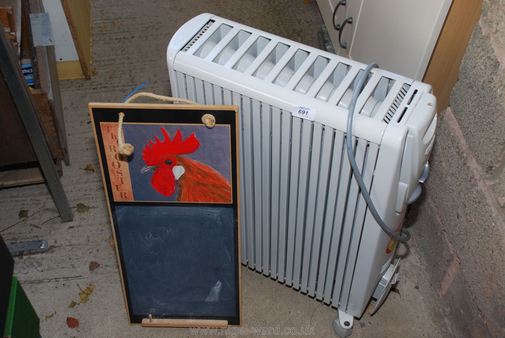 An oil filled radiator and a kitchen memo board.