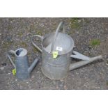 A galvanised watering can plus another.