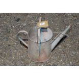 A small galvanized watering can.