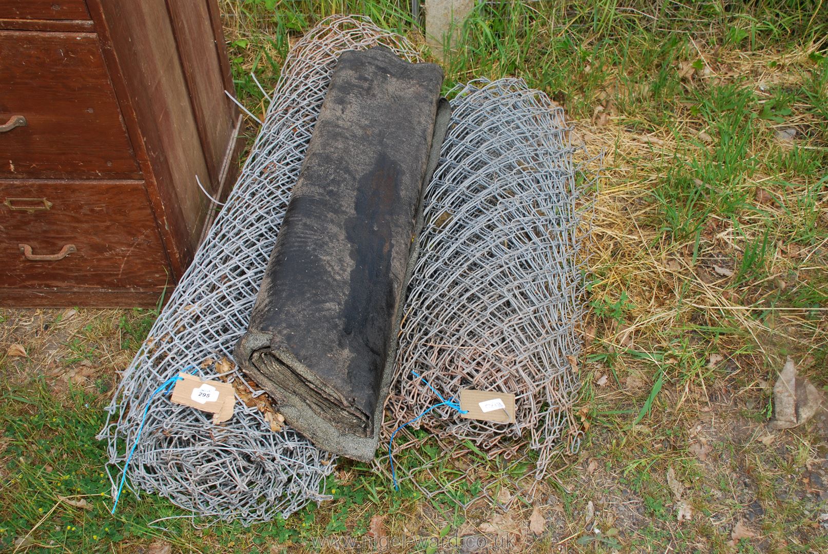 Two coils of chain link fencing and a part roll of roofing felt.