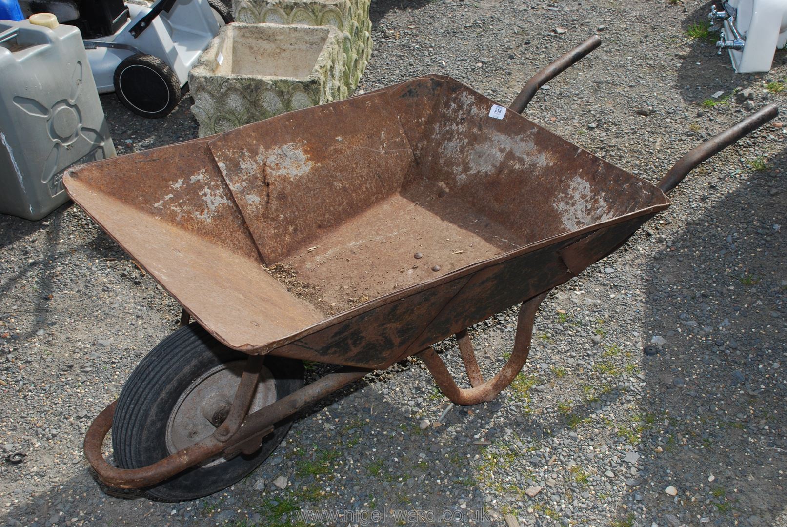 A metal Wheelbarrow on pneumatic tyre.