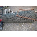 A large roll of plastic coated 6' high chain-link Fencing.