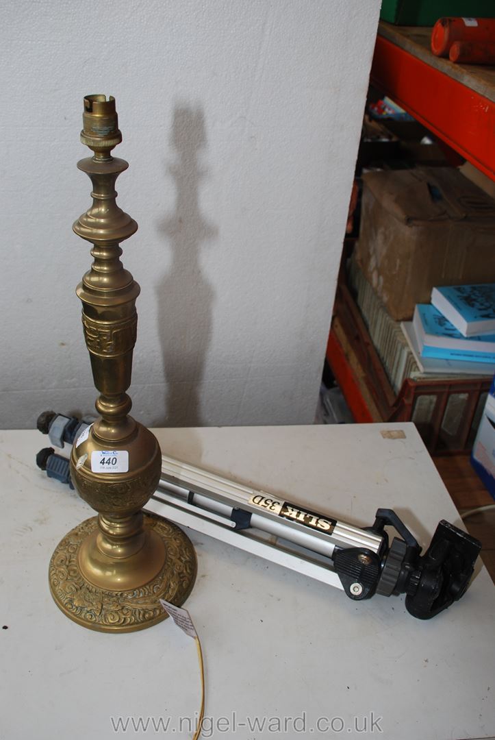 A tall Brass table Lamp and a photography Tripod.