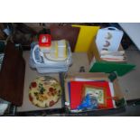 A quantity of coloured chopping boards, trays, white large cooking dishes etc.