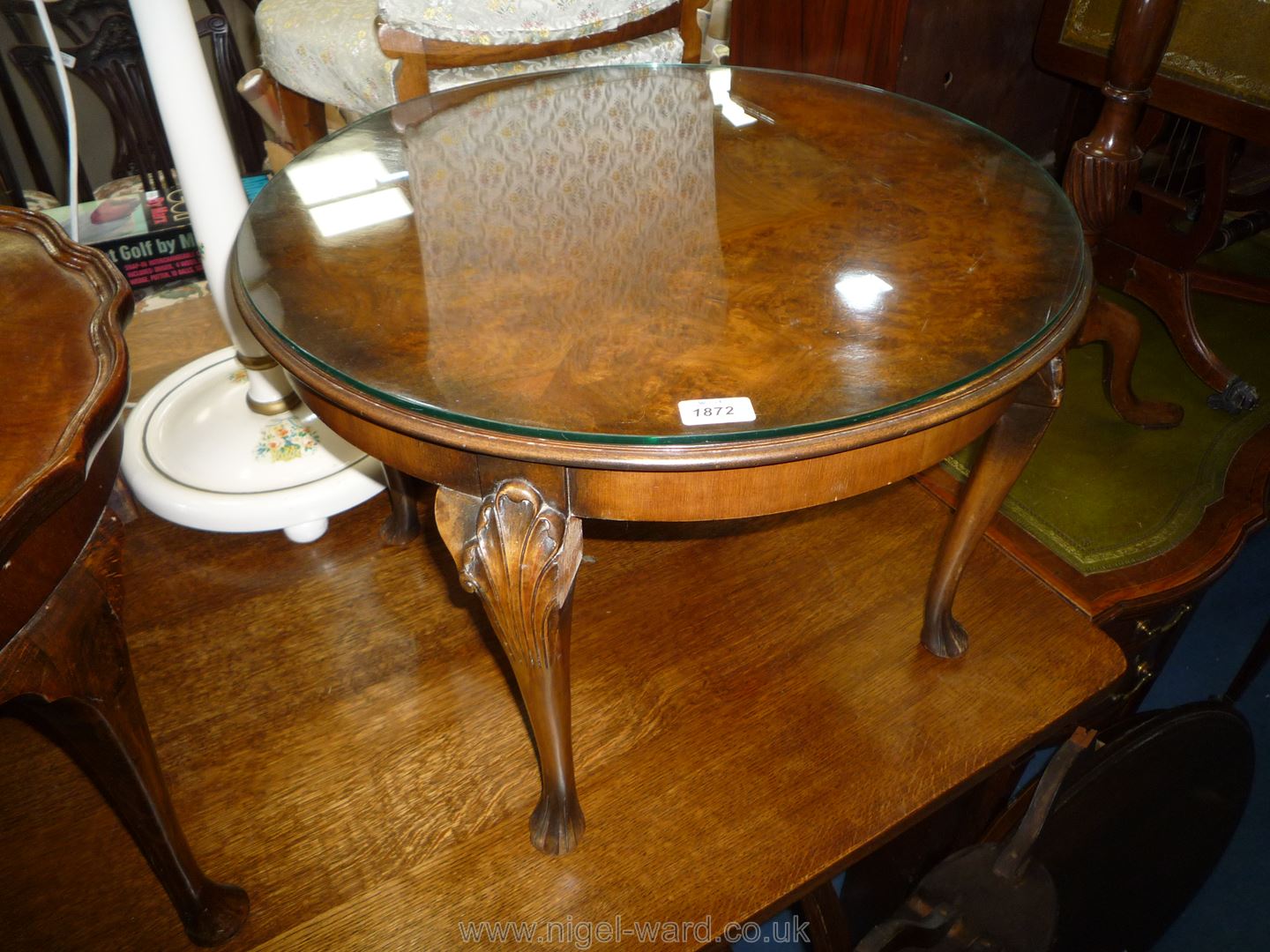 A circular 1/4 veneered top Coffee Table standing on cabriole legs with fluted knee details,