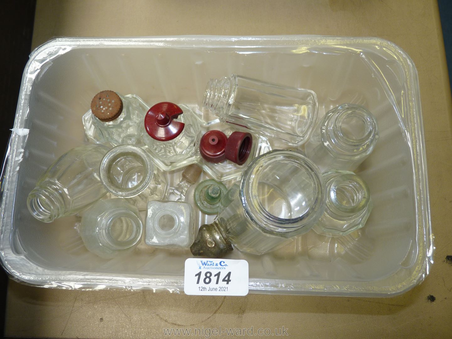 A small tub of glass condiment bases and stoppers.