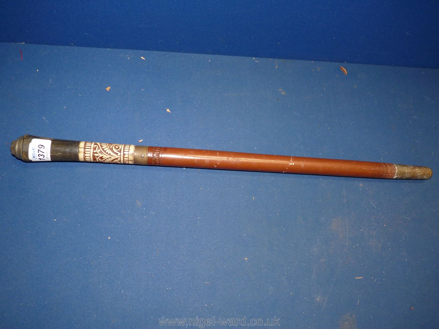 A wooden and ebony swagger stick having carved bone decoration and carved lion top.