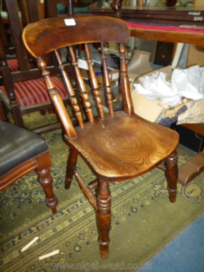 An antique solid Elm seated kitchen Chair having turned details to the back and to the legs and