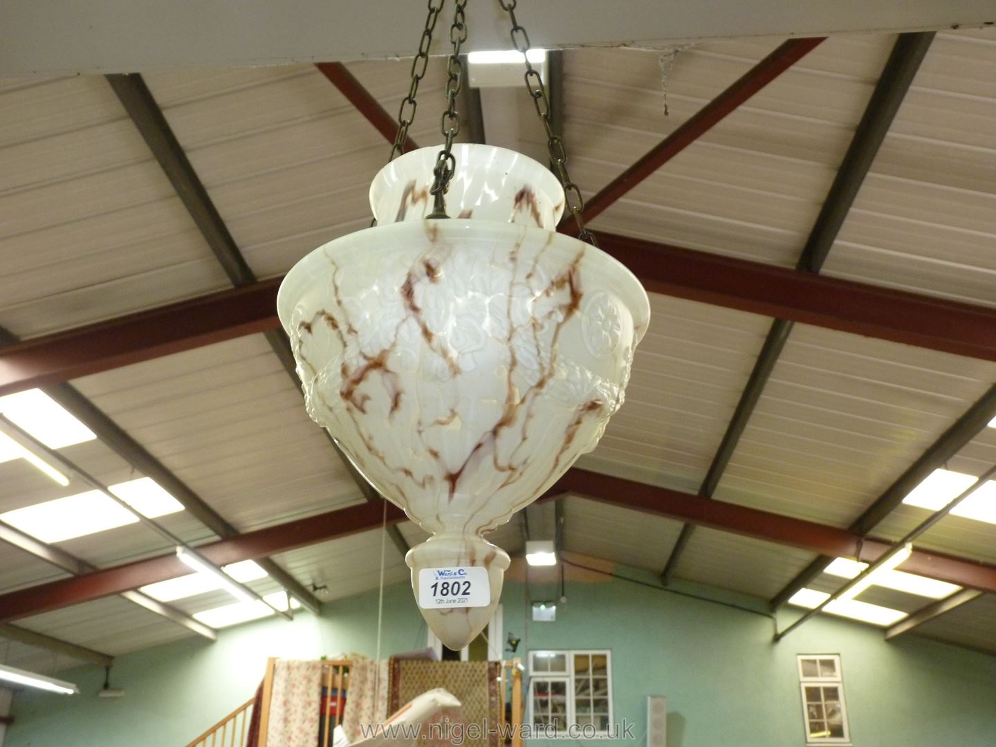 A hanging glass lamp shade in brown and white mottled tones with embossed rope decoration.