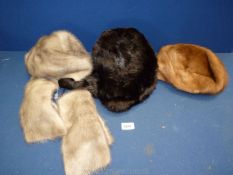 Three fur hats: one grey with scarf, one brown and black Trapper hat.