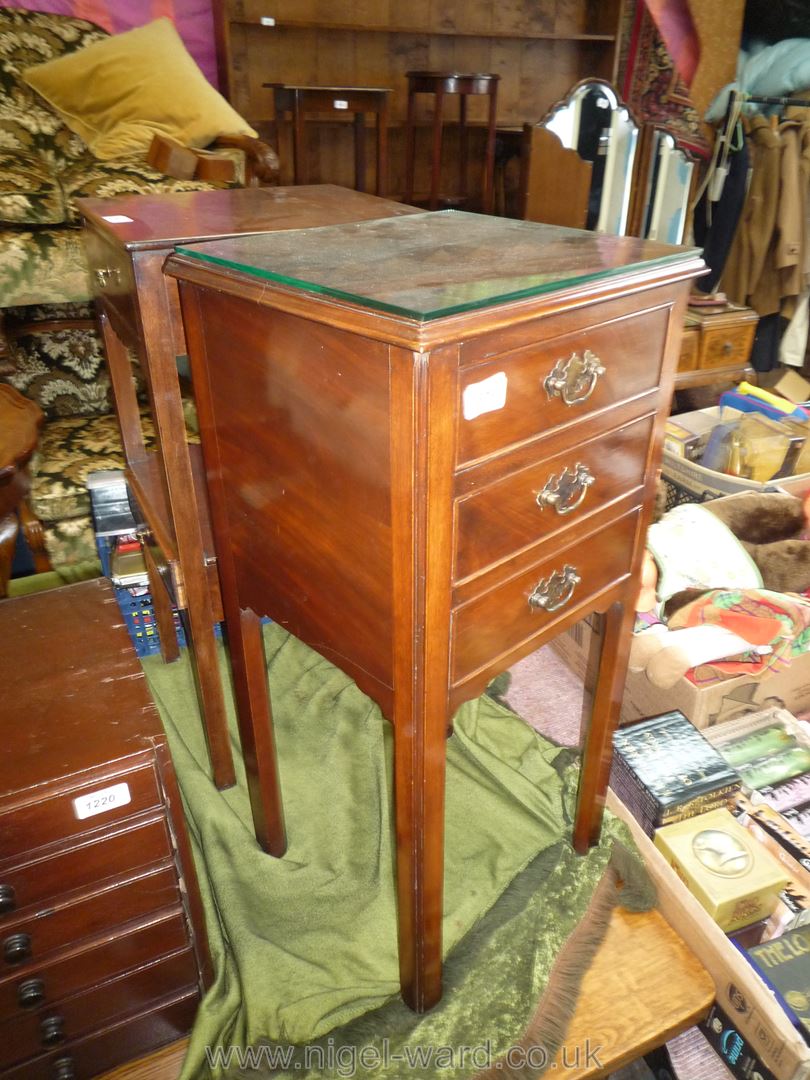 A Bedside night Stand having three short drawers and standing on square legs with moulded corner