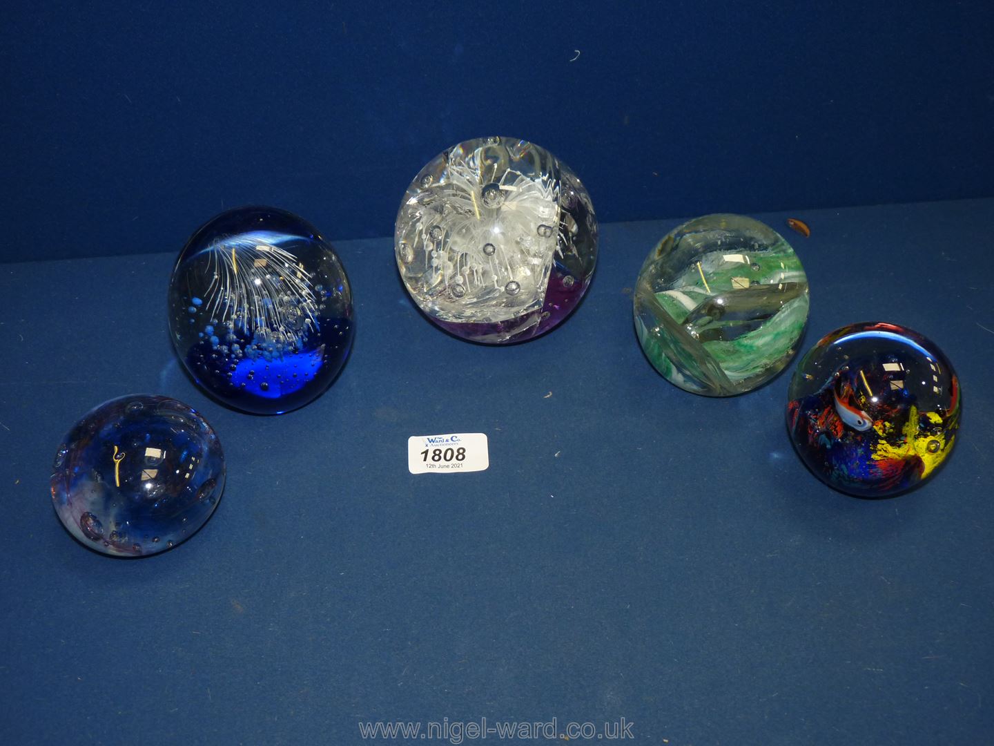 Five paperweights including large white, blue, green, multi-coloured etc., some damage.