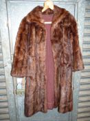 A brown fur coat, size medium, with pockets, lining a/f.