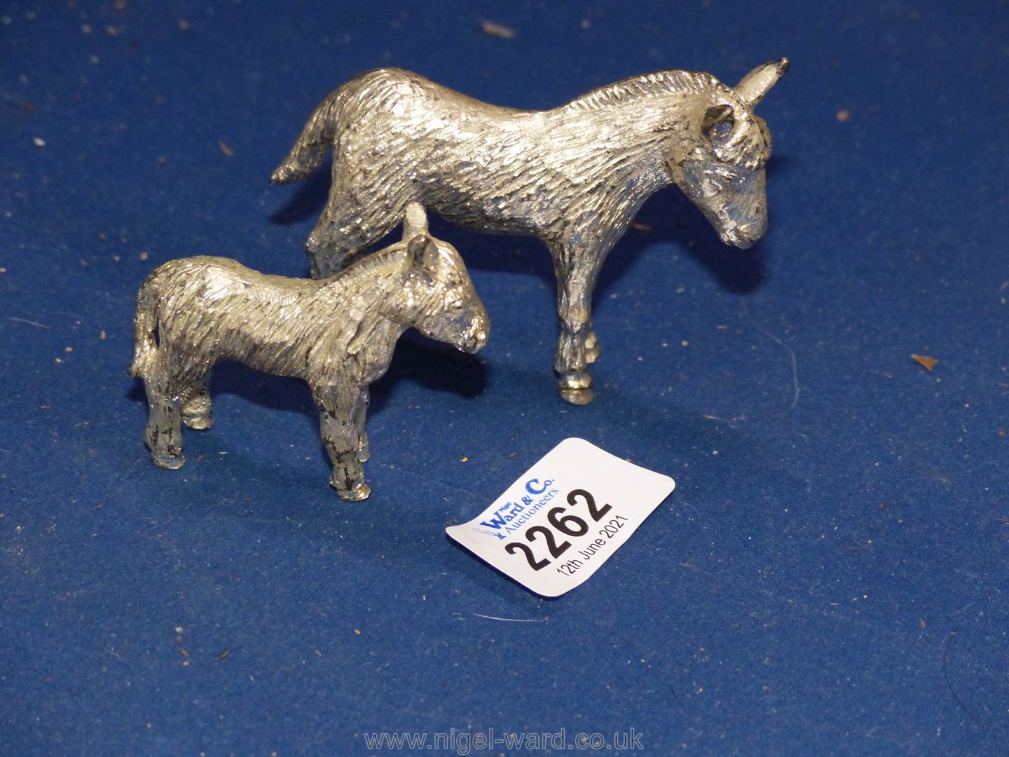 Two small white metal Donkeys.