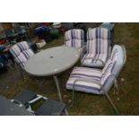 Four metal framed garden chairs with cushions and a 37'' diameter glass topped table.